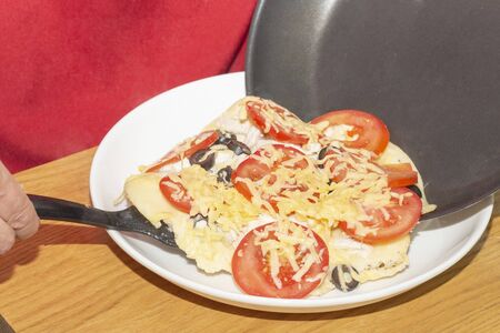 pizza with tomatoes, olives, cheese cooked in a pan at homeの写真素材