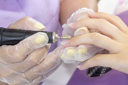 grinding and processing of the nail plate. manicure master makes hardware manicure to the client. nail polishing before applying gel polish. shellacの写真素材