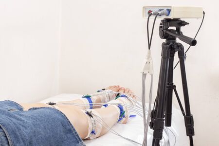 rheogram of the lower extremities. patient's legs on rheovasography. silver-plated electrodes are...
