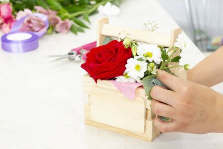 business, sale and floristry concept - close up of florist woman holding bunch at flower shop. Soft shades of fresh spring flowers. の写真素材