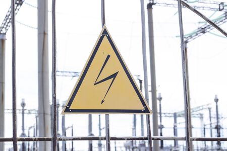 High Voltage Sign and Symbol Caution Signboard on Fence Wire at Electrical Power Plant Stationの写真素材