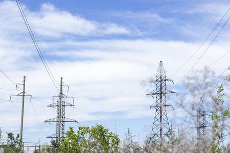 Power Tower. High voltage lines and power pylons in a flat and green agricultural landscape. City power substation, close-up, transformer with high-voltage wiresの写真素材