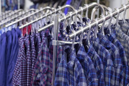 Clothes hang on a shelf . Cloth Hangers with Shirts. Mens business clothes. clothing supermarketの写真素材