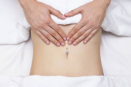 Massage Therapist Massaging a Womens Stomach. Massage and body care. Spa body massage woman hands...