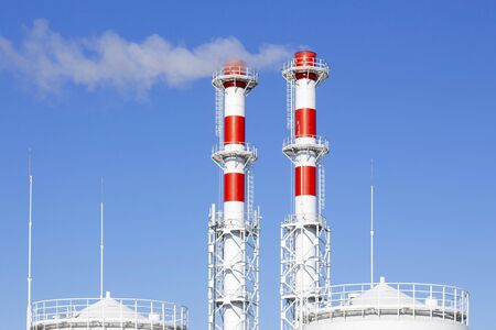 Factory plant smoke stack over blue sky background. Thermal condensing power plant. Energy generation and air environment pollution industrial sceneの写真素材