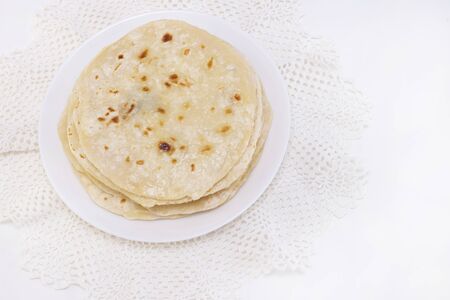 indian chapati bread. chapati on a white plate on a white background.