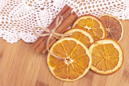 Cinnamon sticks, slices of dried orange, on wooden background. View from above. Christmas and New Year celebration concept. winter and autumn.の写真素材