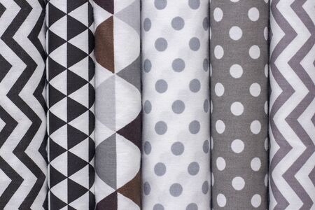 cotton fabric texture background. Geometric colors. white, gray, black colors. Shelf with fabrics in...