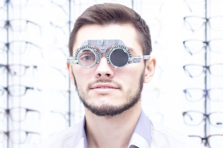 Ophthalmologist examines the young man in the clinic. Consultation of an ophthalmologist. Medical...