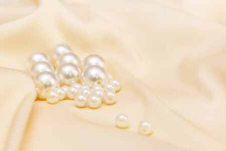 Abstract luxury fabric background with pearl beads. silk natural fabric. Silk golden beige fabric texture with pearls.の写真素材