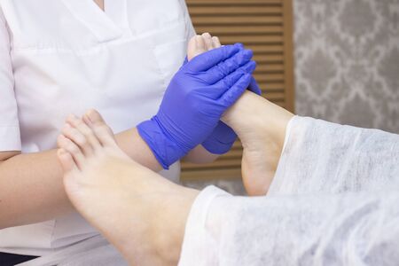 Foot massage in spa salon, closeup. foot massage relax skin care. Therapeutic pedicure.