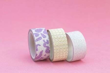 decorative tape for scrapbooking. Adhesive tape with glitter, gold, silver. on a pink background