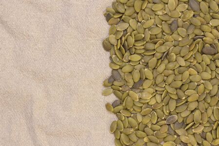 Background. pumpkin seeds on natural flax. pumpkin seeds vitamins of group B and magnesium.の写真素材