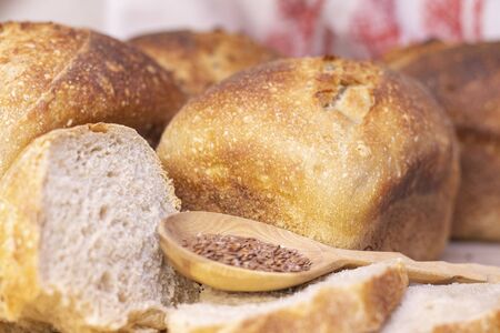 Bakery - golden rustic bread crusts. Fresh aromatic bread on the table. Food concept. wooden spoon...