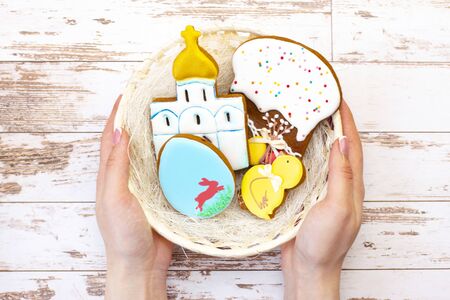 Easter holiday. Colored eggs in a basket. Easter gingerbread cookies chicken, egg, temple, Easter...