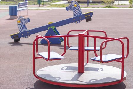 empty swings and carousels at the playground. quarantine due to virus. coronavirus. All children are at home. in quarantine.の写真素材