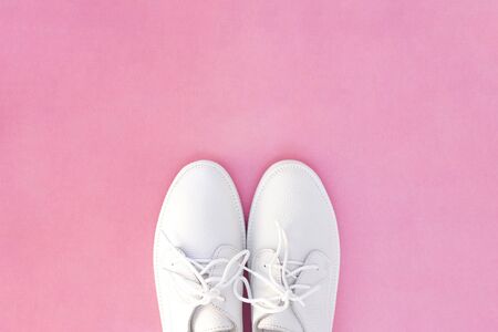 white sneakers on a pink background. top view. copyspace. place for textの写真素材