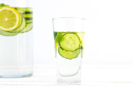 Health care, fitness, healthy eating concept. Fresh cool lemon cucumber drink with water, cocktail, detox drink, lemonade in a glass jug and a glass.の写真素材