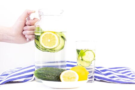 Health care, fitness, healthy eating concept. Fresh cool lemon cucumber drink with water, cocktail, detox drink, lemonade in a glass jug and a glass.の写真素材