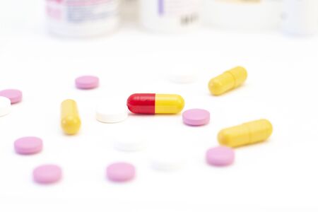 pills and capsules of different colors on the background of many drugs. The concept of health care,...