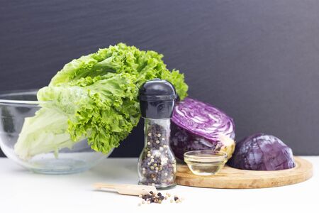 vegetarianism. ingredients for a light salad. Purple cabbage, lettuce, peas and olive oil on a white table.の写真素材