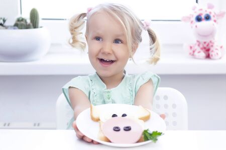 sandwich bull.   girl hands have a white plate with a sandwich for breakfast or lunch.の写真素材