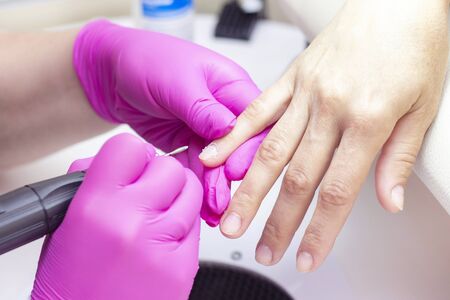 HardWear manicure. manicurist in pink gloves manicures a girl.の写真素材