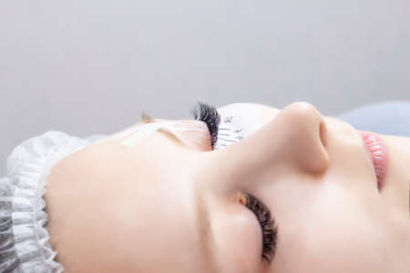 Eyelash extensions. Closeup of eyes with extended eyelashes and without extended eyelashes, white...