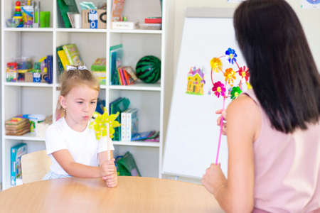 developmental and speech therapy classes with a child-girl. Speech therapy and spinning games. girl blowingの写真素材