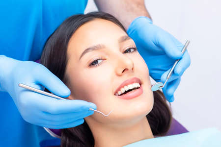 Young Female patient with pretty smile examining dental inspection at dentist clinic. Healthy teeth and medicine, stomatology conceptの写真素材