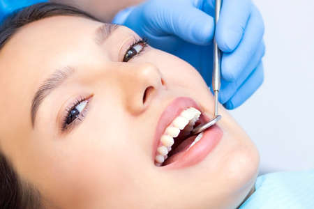 Young Female patient with pretty smile examining dental inspection at dentist clinic. Healthy teeth and medicine, stomatology conceptの写真素材