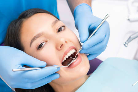 Teeth health concept. Cropped photo of smiling woman mouth under treatment at dental clinicの写真素材