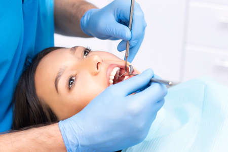 Attractive young woman in a dental clinic with a male dentist. Healthy teeth concept.の写真素材