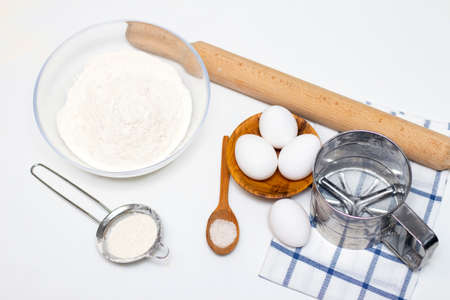 making dough for bread or homemade baked goods. ingredients on the table. against the background of...