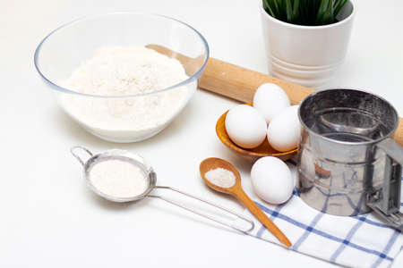 making dough for bread or homemade baked goods. ingredients on the table. against the background of...