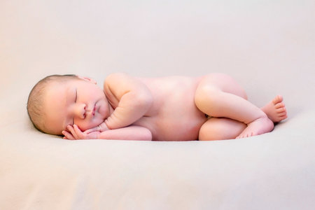 Funny newborn baby sleeping peacefully naked.の写真素材