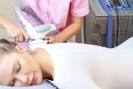 Beautiful woman getting beauty therapy against cellulite with LPG machine on her butt. LPG massage for lifting bodyの写真素材