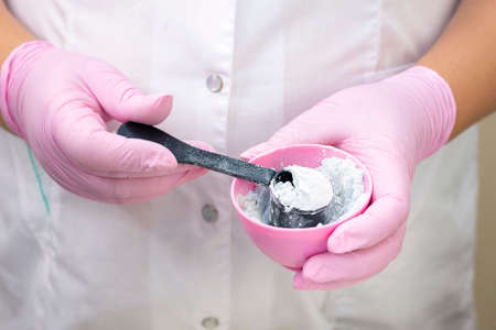 cosmetologist is preparing an alginant maskの写真素材