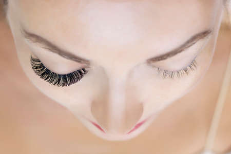 Eyelash extension procedure. Woman eye with long eyelashes. Close upの写真素材
