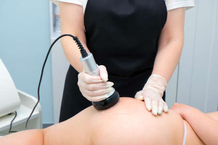 Body cavitation treatment. Ultrasound care to fat reduction. Beauty ultrasonic massage therapy at salon. Anti cellulite massage for buttocks and thighsの写真素材