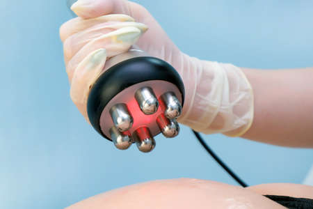 doctor does the Rf lifting procedure on the legs, buttocks and back, hips of a woman in a beauty parlor. Treatment of overweight and flabby skin.の写真素材