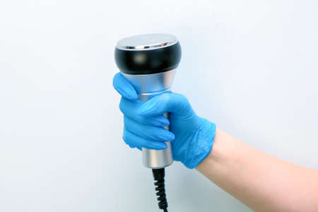 apparatus massager ultrasonic rf lifting in the hand of a beautician in a glove