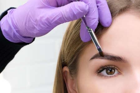 Young woman shaping eyebrows with brush, close upの写真素材