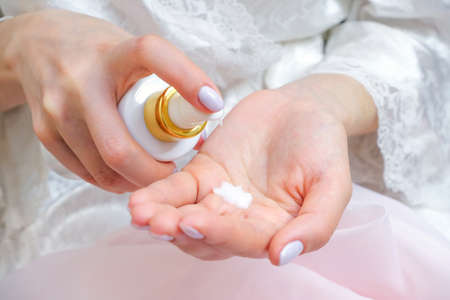 young woman applies hand cream from a tube of cream. beautiful well-groomed hands and palm with...