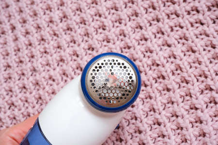 Electric device for removing hair and fluff in pink fabric texture. Shaver for woolの写真素材