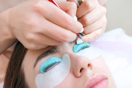 Young woman receiving eyelash lamination procedure in a beauty salon, close upの写真素材