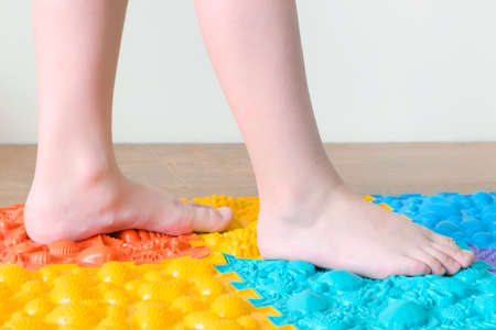 foot massage. Childrens feet walk on orthopedic mats. Treatment and prevention of flat feet and leg diseasesの写真素材