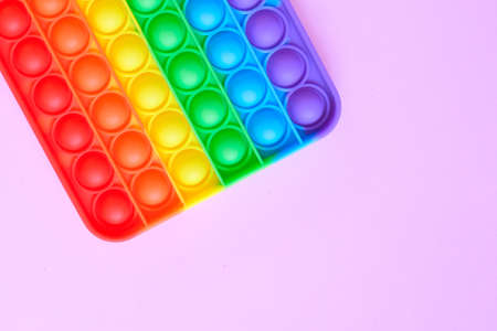 Rainbow pop it toy fidget on a background of empty copy space. pink backgroundの写真素材