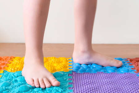 foot massage. Childrens feet walk on orthopedic mats. Treatment and prevention of flat feet and leg diseasesの写真素材