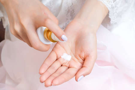 young woman applies hand cream from a tube of cream. beautiful well-groomed hands and palm with cream. close-upの写真素材